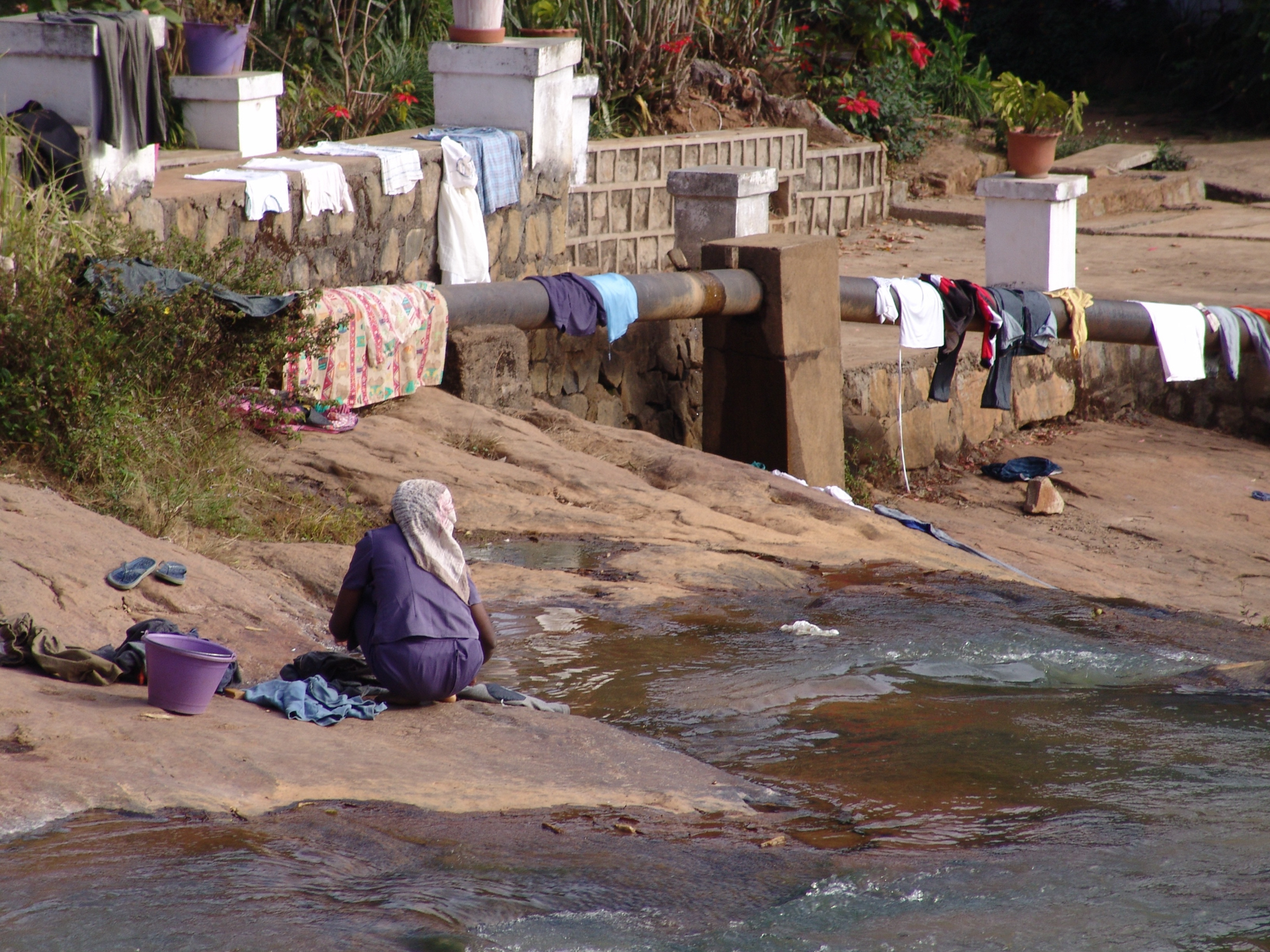 Lady washing her personal belongings along a stream in Madagascar