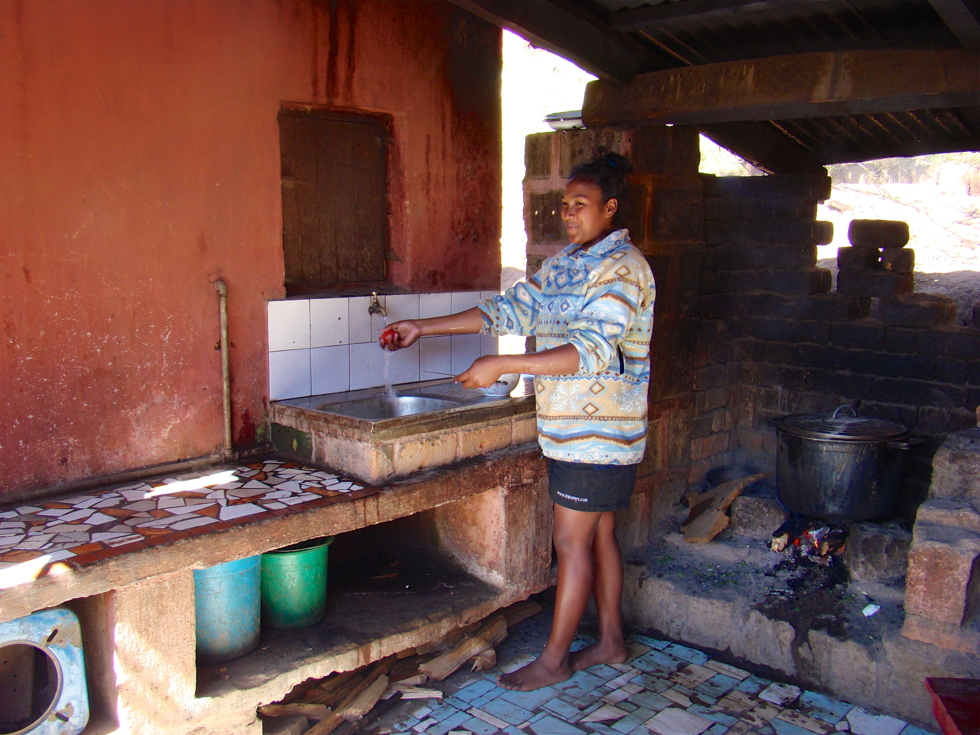 A woman washing her hands with running water in Le Triomphe's Children's orphanage in Madagascar