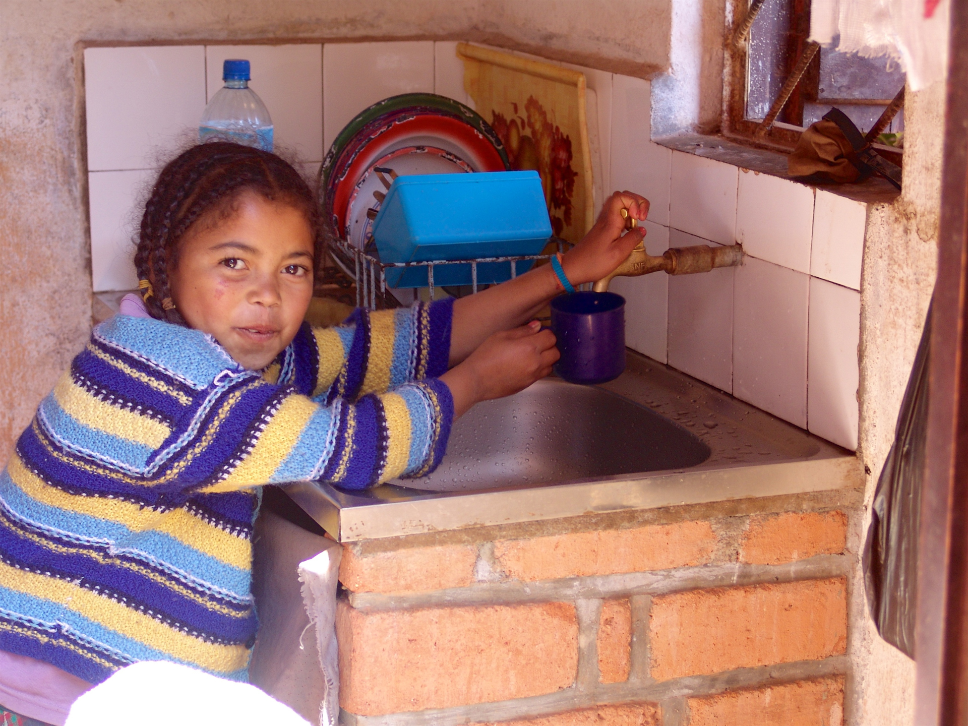 Young girl seeing clean water on tap for the first time